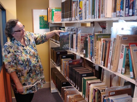 CDU Library Director Ruth Quinn with some of the catalogued monographs in the Sherlock Collection. [CHART photo]